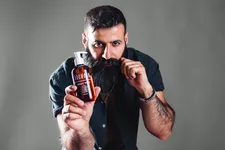 Man with Odenson Beard Wash in hand